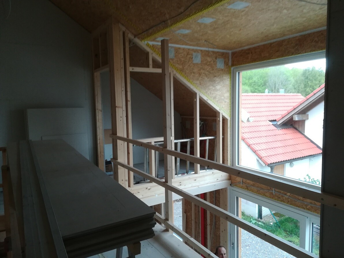 Shell interior: timber studs, staircase, window opening, stacked construction timber