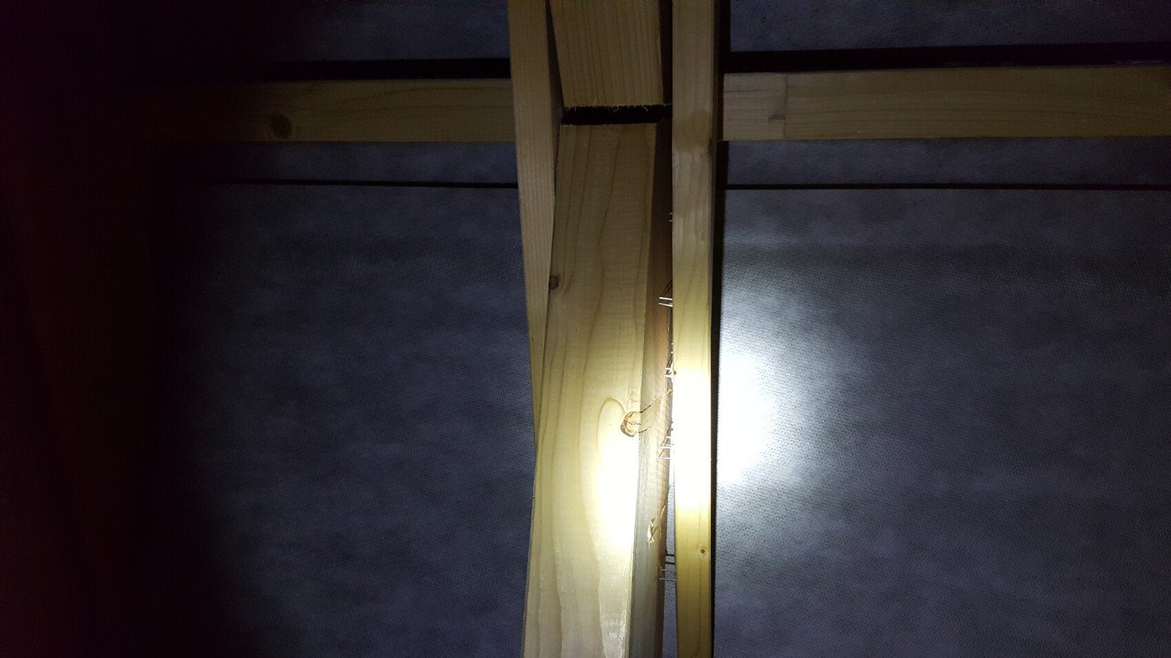 Timber stud wall shell with nails inside a construction site