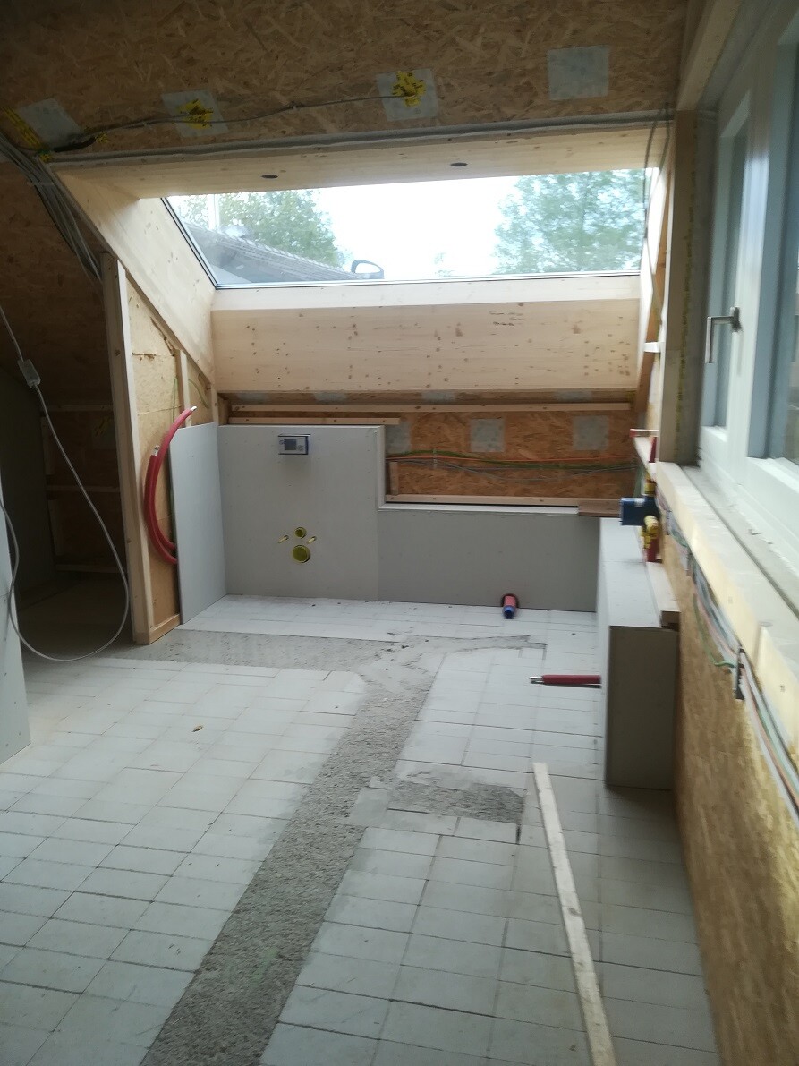 Renovation room with skylight, shell walls, sanitary area and tiled floor.