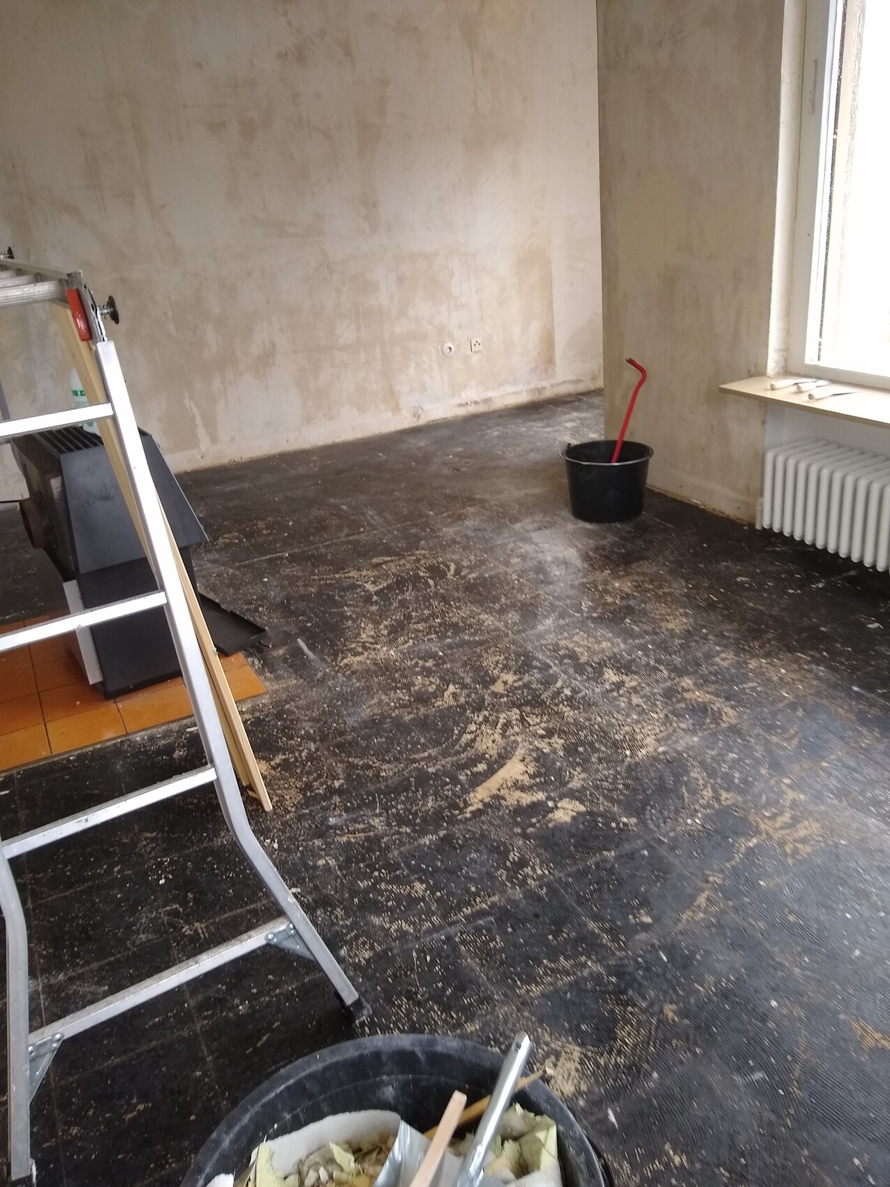 Interior fit-out: ladder, bucket and construction materials in a room in need of renovation