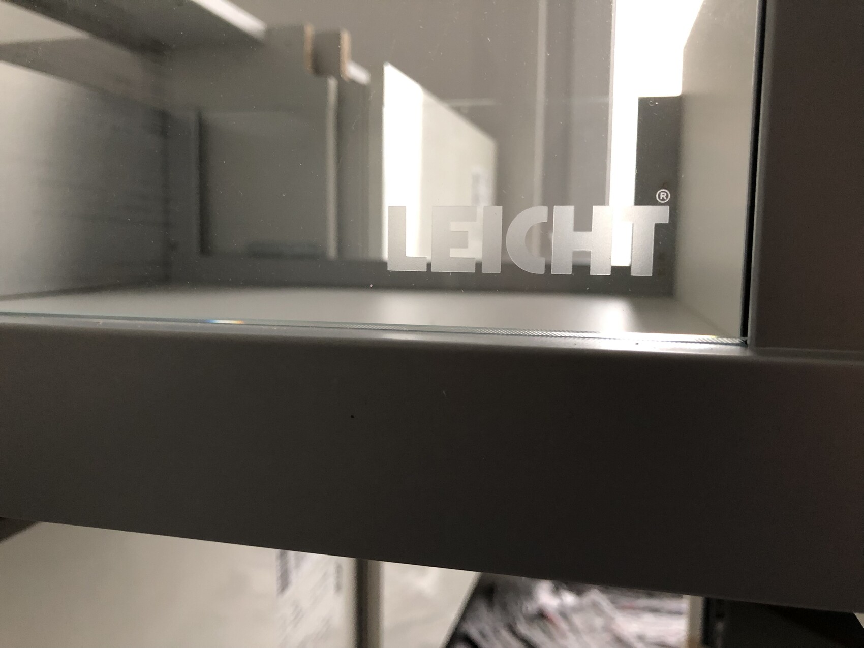 Leicht logo on glass front, lettering on metal frame; background visible