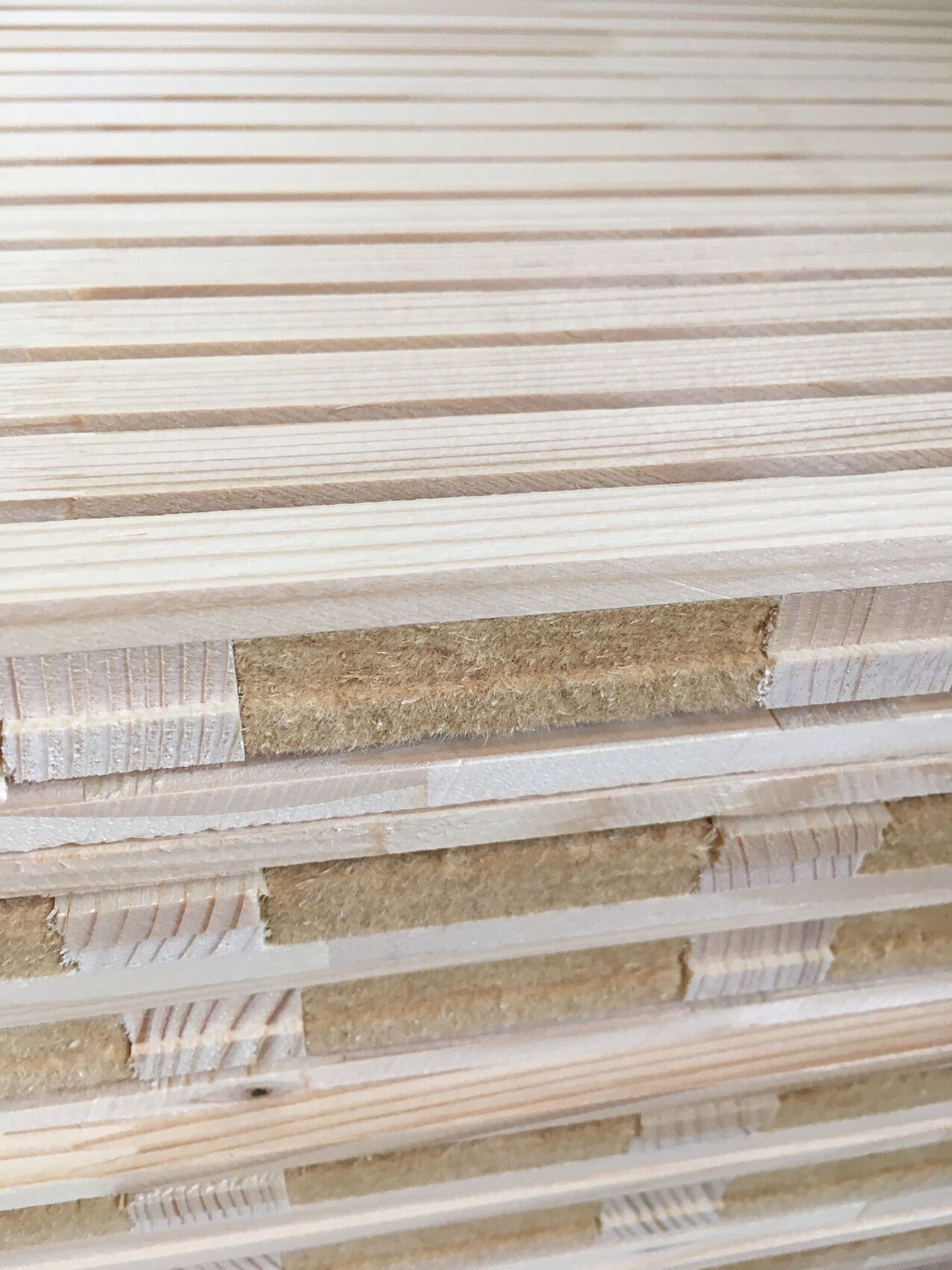 Stack of light wooden boards with visible grain and spacers.