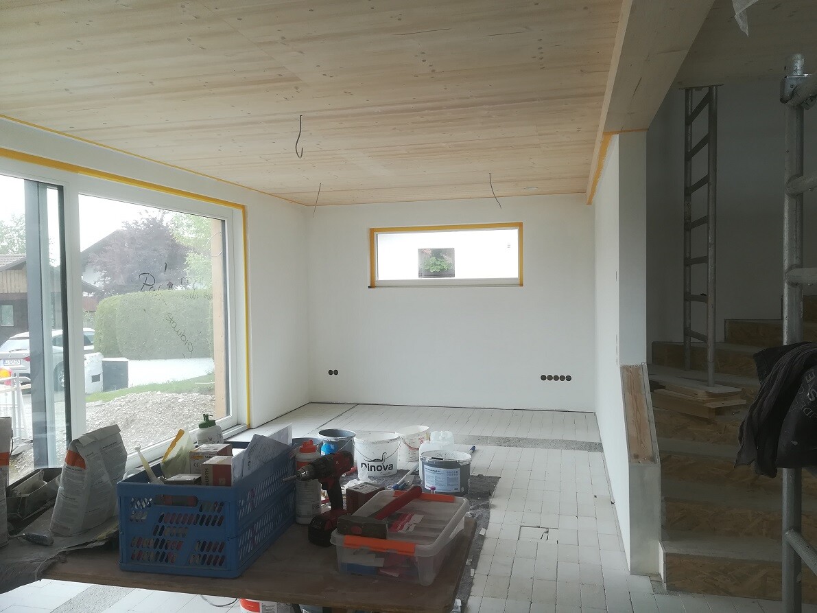 Renovation room with wooden ceiling, large window front, workbench and ladder.