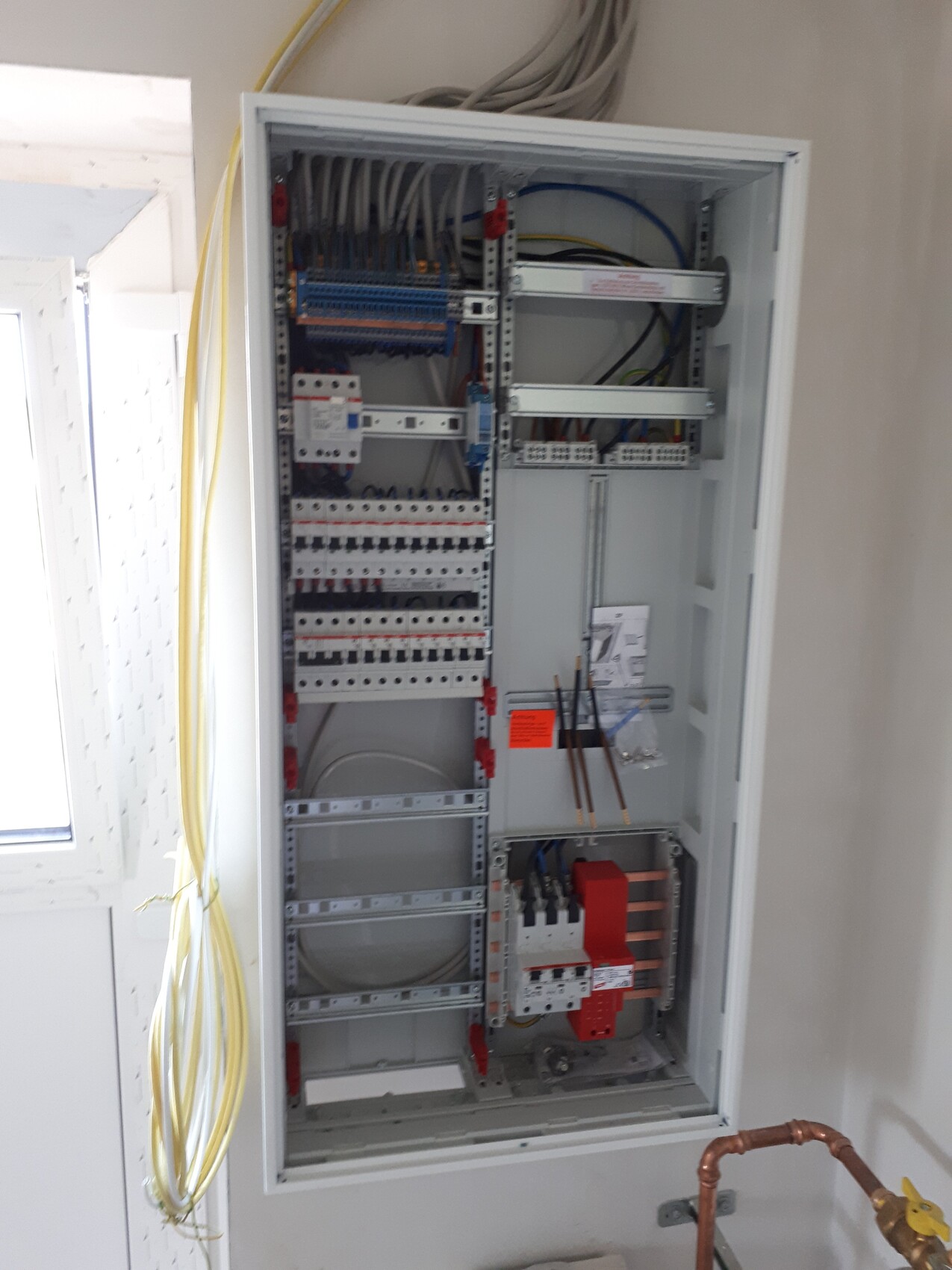 Control cabinet with many fuses, cable bundles, and control components for energy distribution