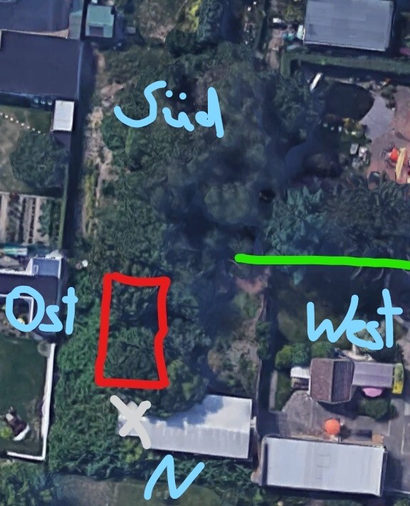 Aerial photo of a plot with a red rectangular marking, green line and blue directions.
