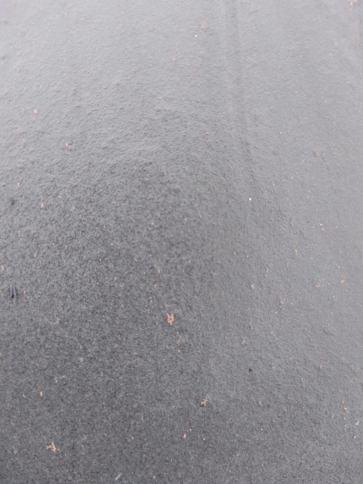 Dark asphalt floor with small gravel, outdoor area