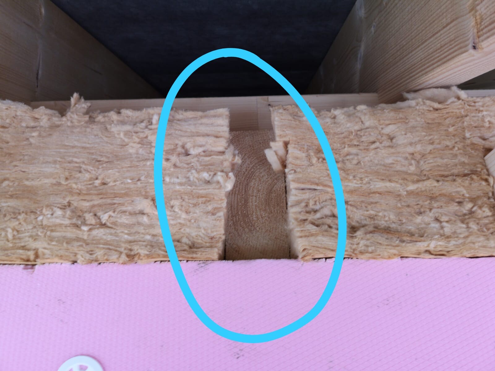 Construction site scene with insulation between wooden beams in the wall