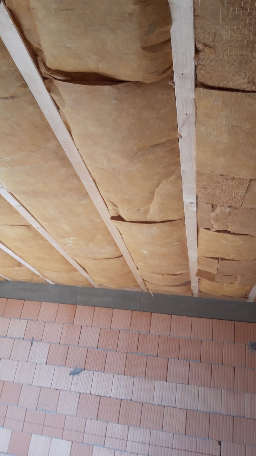 Construction site: insulation visible between wooden studs in wall structure