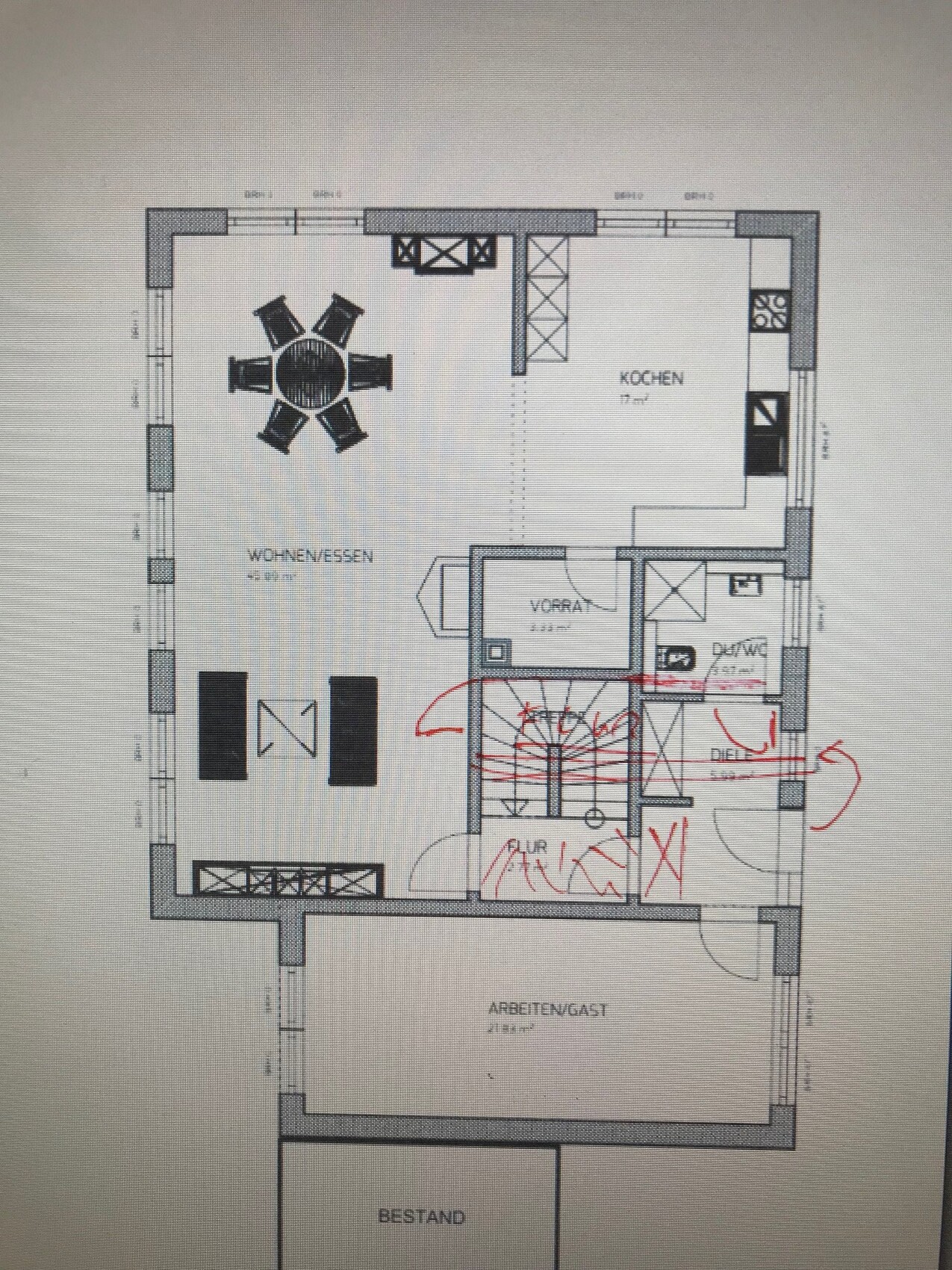 Floor plan of an open living and dining area with kitchen, dining table, sofa, staircase, and hallway.