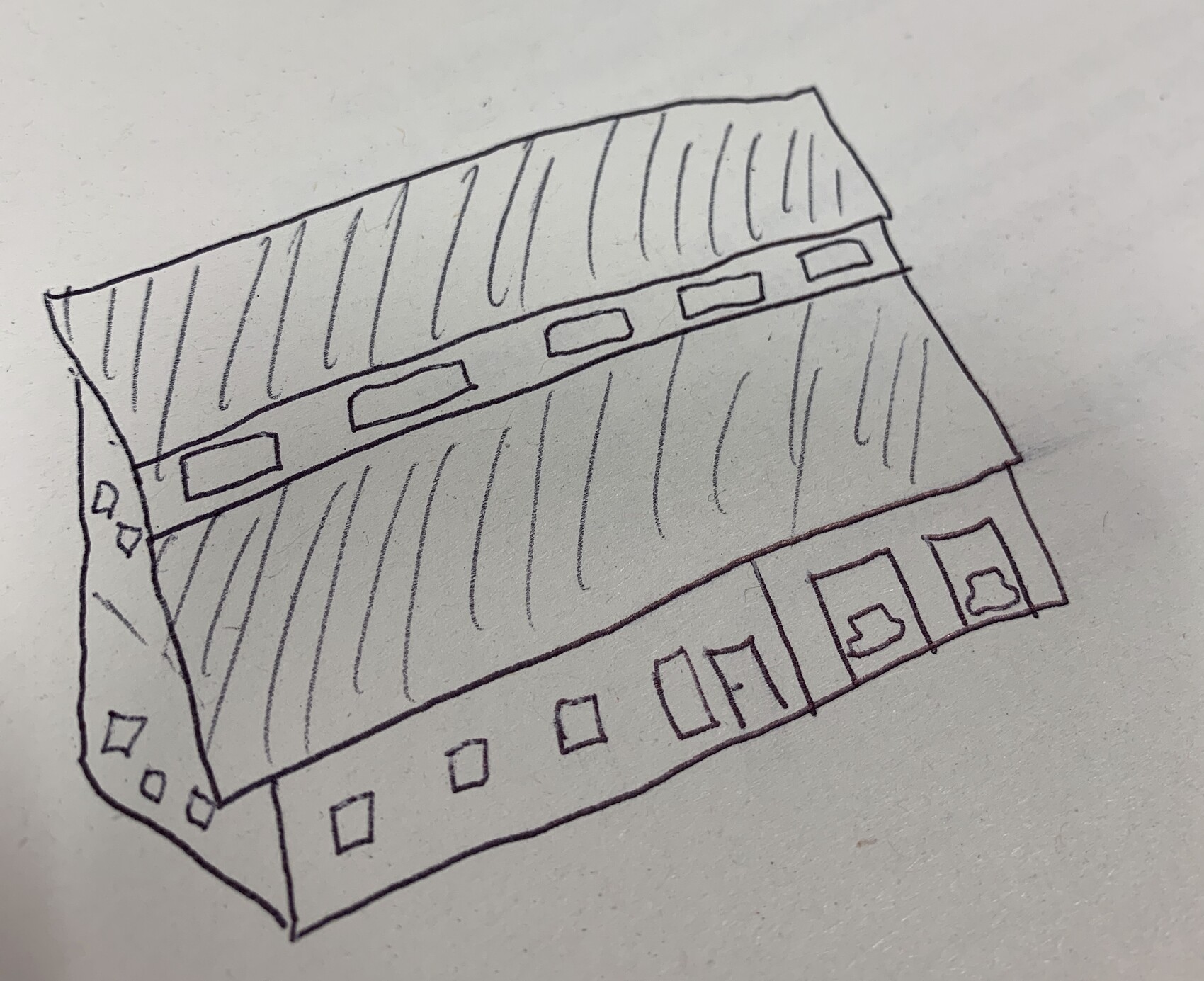 Rectangular two-story building sketch with sloped roof, rows of windows and doors.