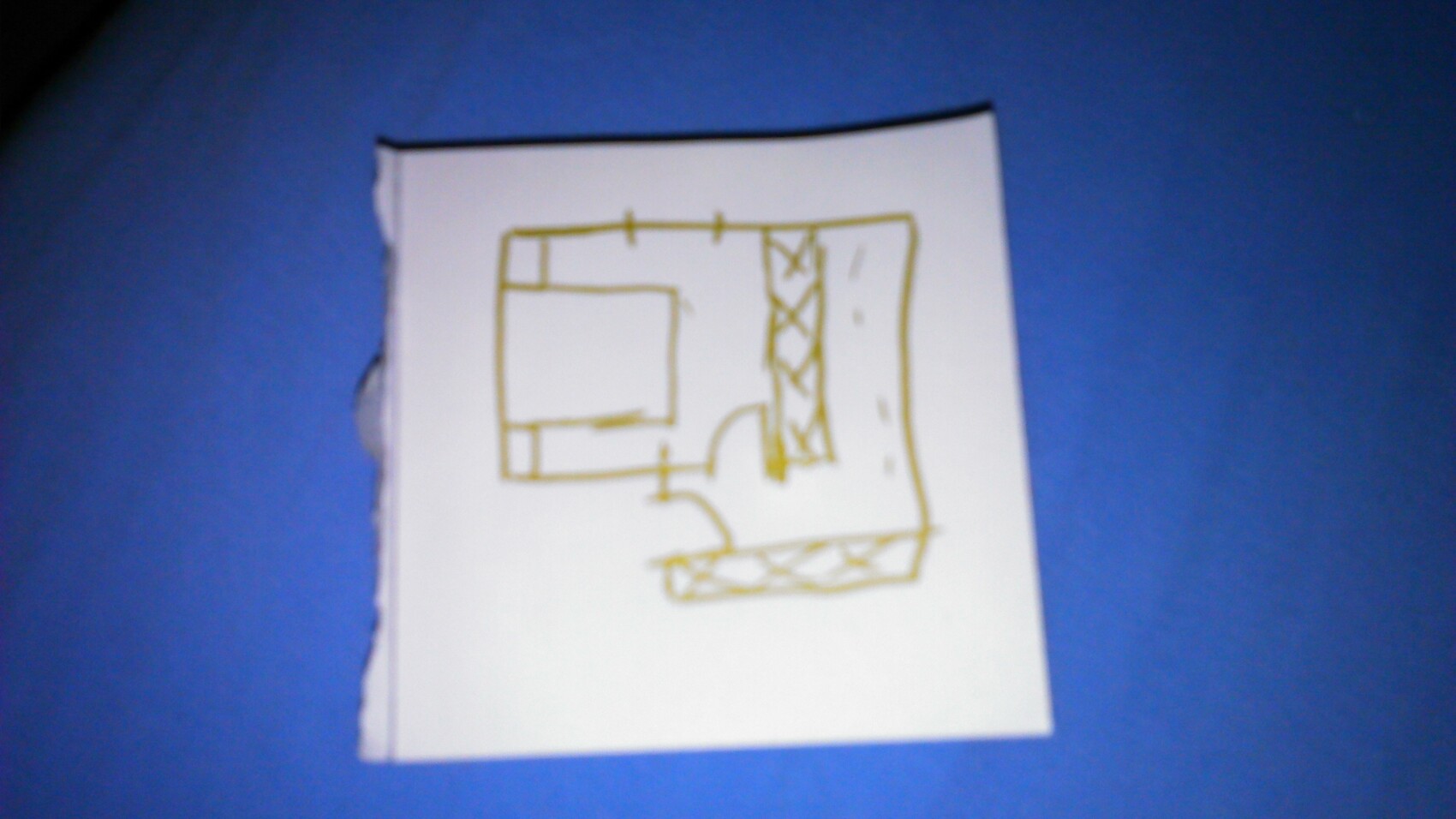 Hand-drawn floor plan sketch on paper with yellow pencil showing room layout
