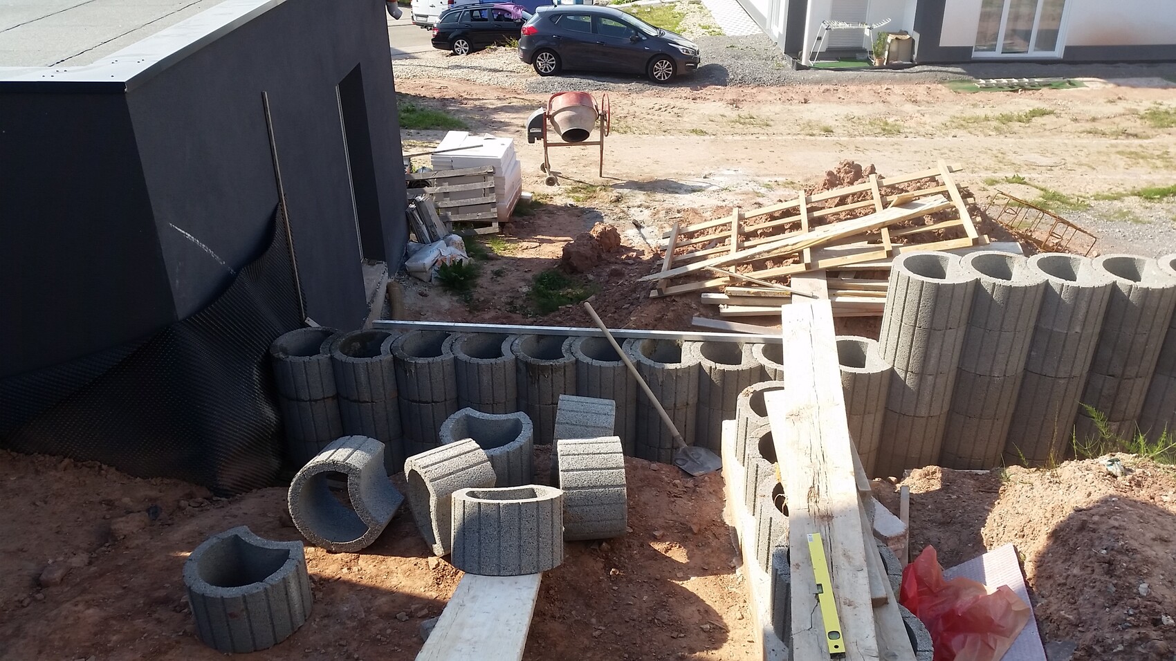 Construction site with concrete blocks, building materials, and debris at the shell foundation