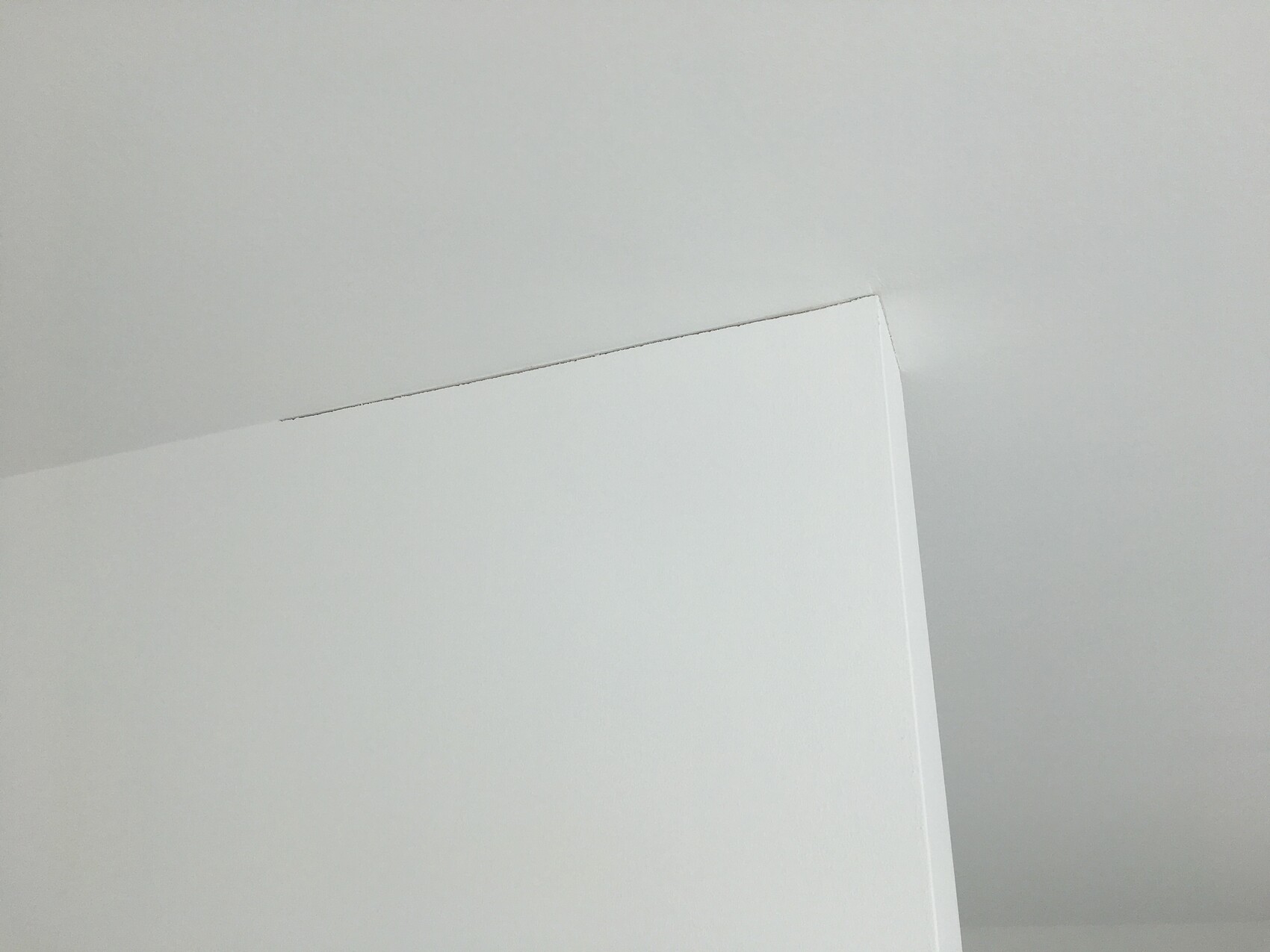 White interior wall with an angled corner and smooth surface.