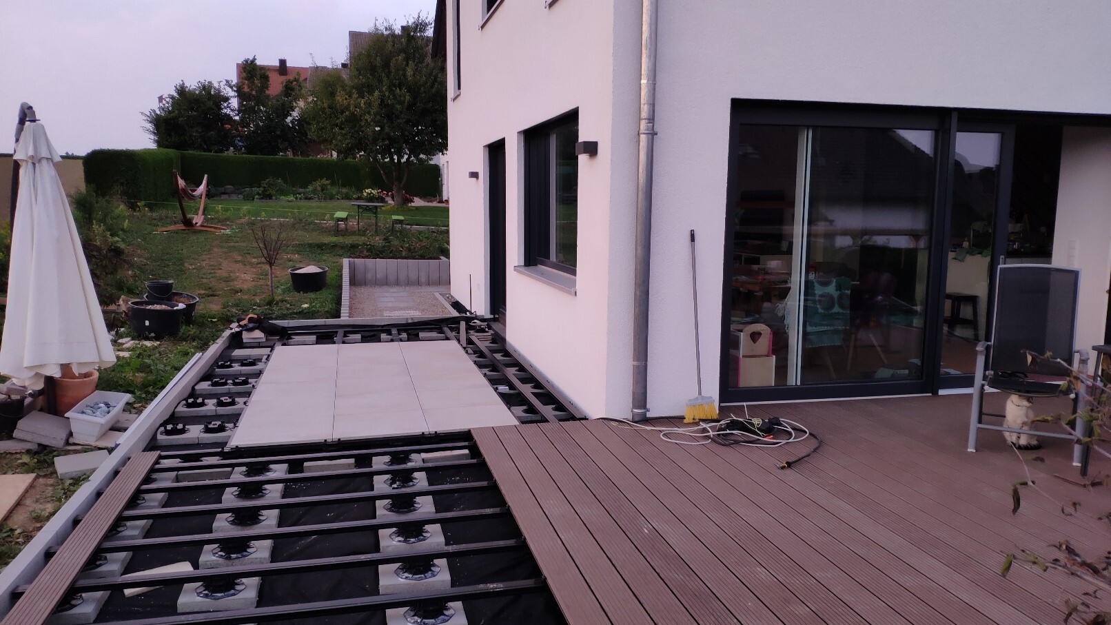 Partly finished terrace construction at the house, garden with hammock and sunshade.