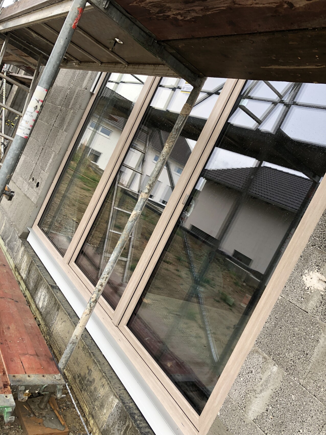Newly installed window in the shell construction with scaffolding and formwork visible