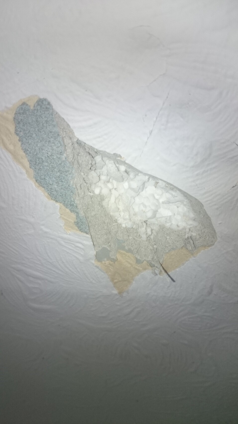 Fragment of ceiling plaster with multiple layers of plaster and a coarse, porous texture.