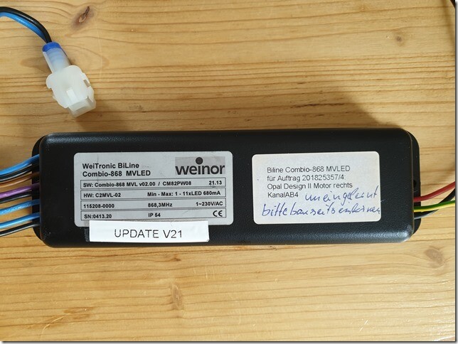 Electronic control unit with cables on wooden table, label visible