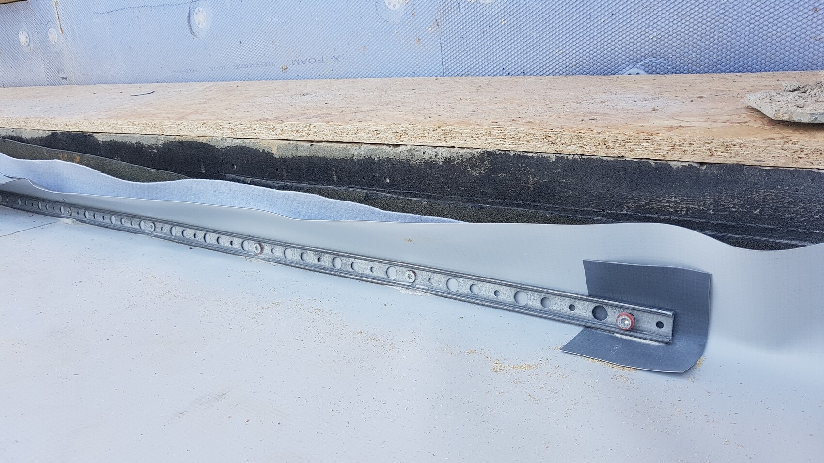 Building wall: wood, bitumen membrane, insulation, metal perforated profile.