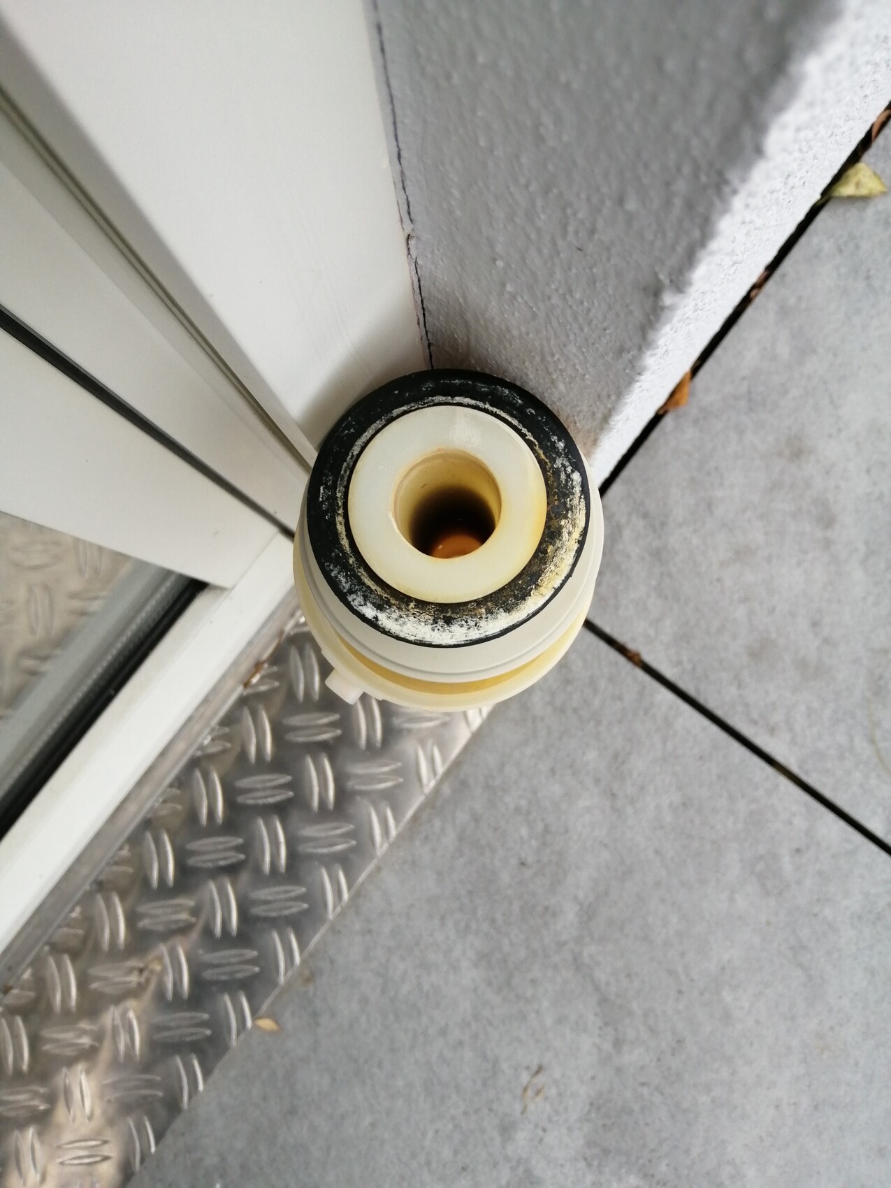 Close-up of a plastic sealing ring on the outer door frame next to the door threshold