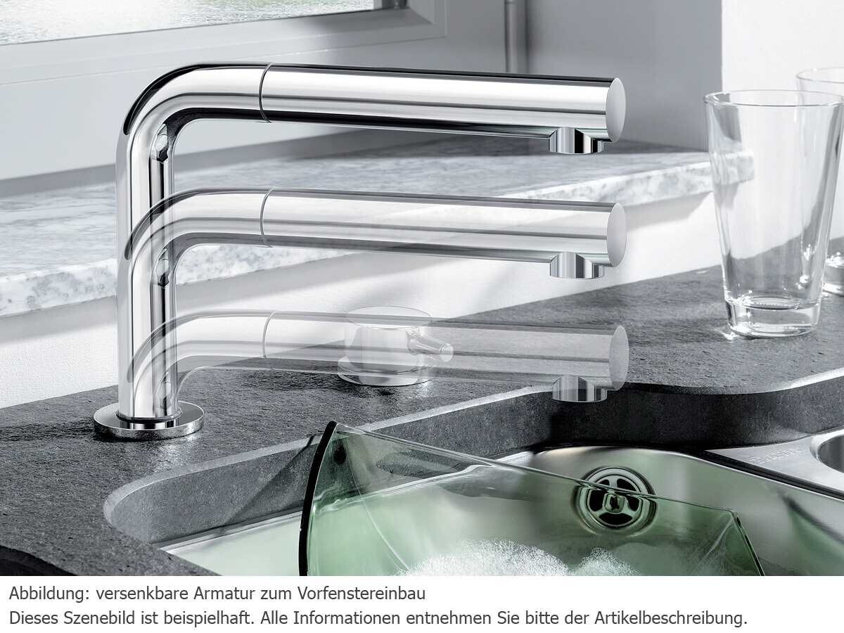 Modern retractable kitchen faucet above the sink in chrome.