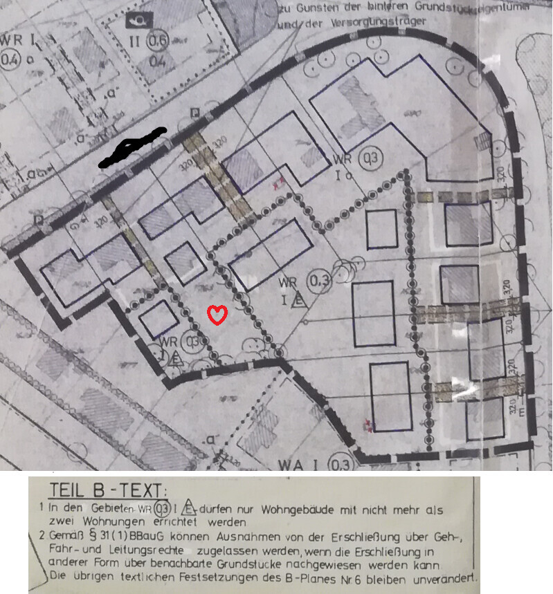 Lageplan eines Baugebiets mit Gebäuden, Wegen und rotem Herz als Standortmarkierung
