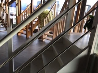 Modern indoor staircase with steel railing and wooden steps in the interior