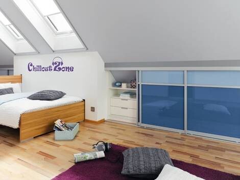 Dachgeschoss-Schlafzimmer mit Bett, Parkettboden, Schiebetüren und Chillout Zone Schild