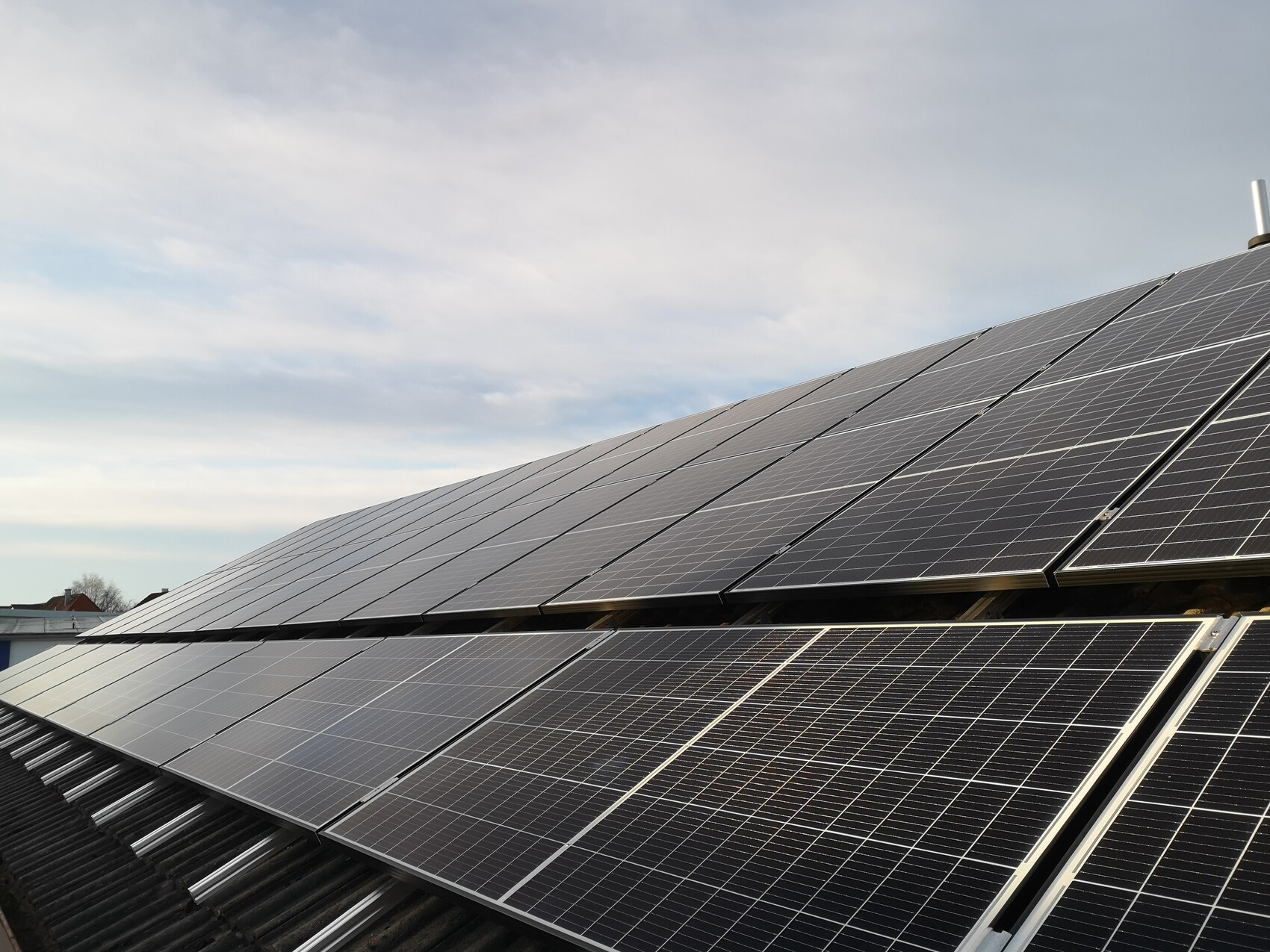 Solar modules on a pitched roof capturing solar energy; clear PV system under blue sky.