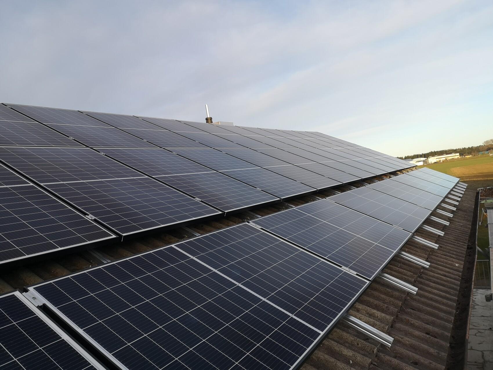 Solar system: Several rows of blue photovoltaic panels on a pitched roof in the background.