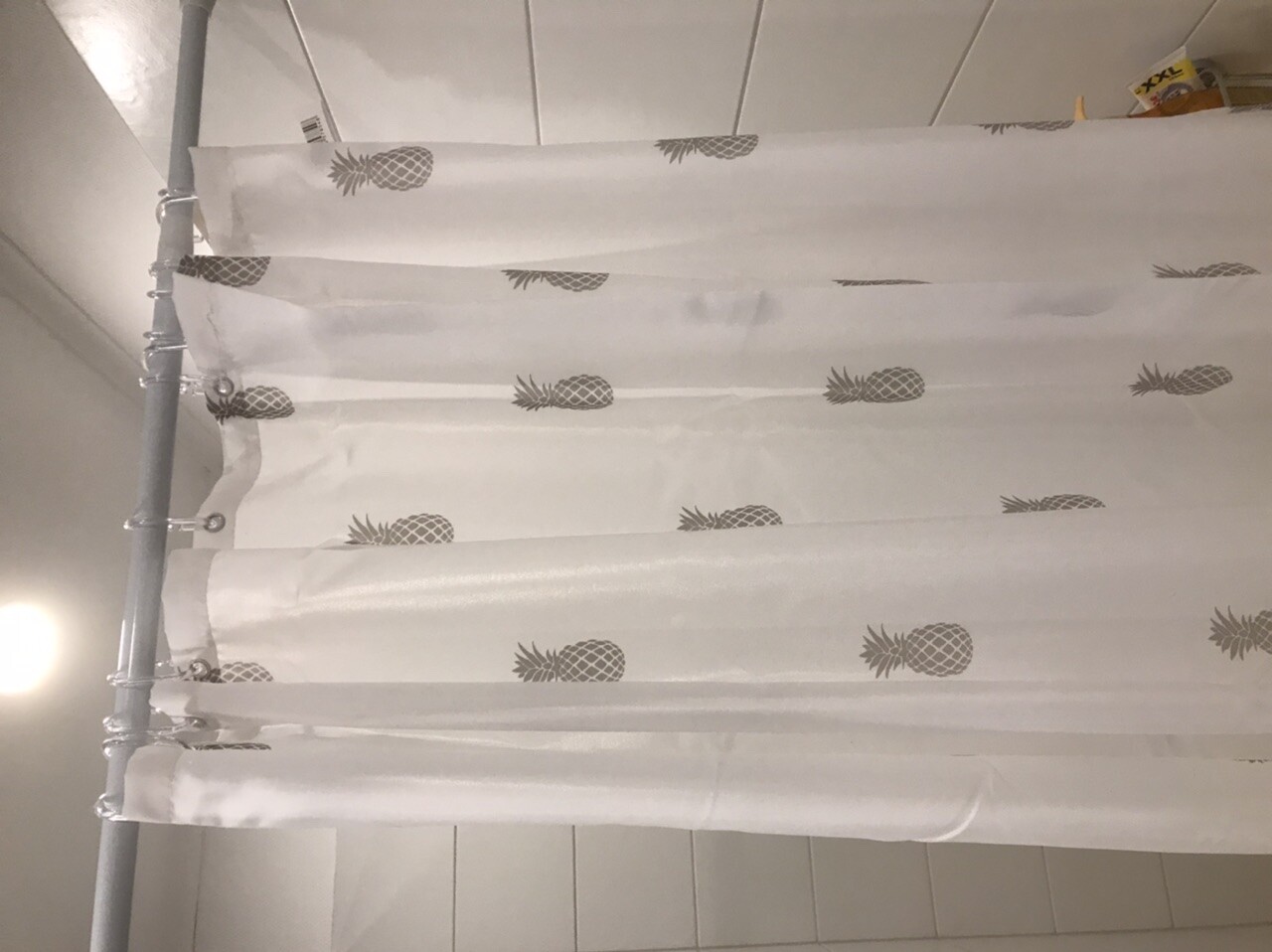 White shower curtain with pineapple pattern in the bathroom