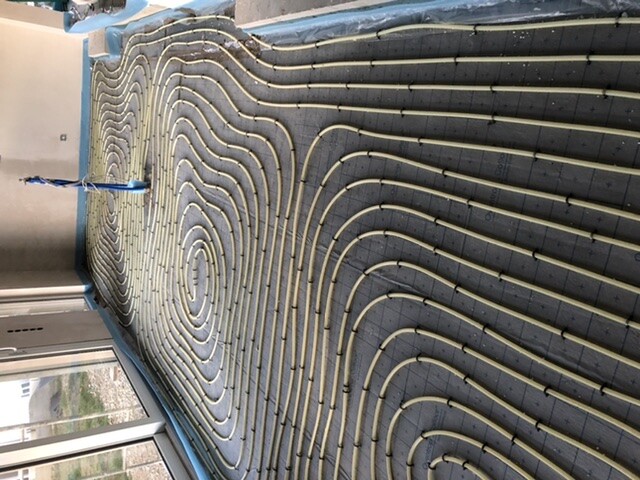 Spirally laid heating pipes on insulation boards for underfloor heating.