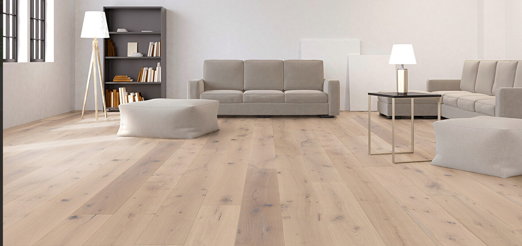 Bright living area with gray sofas, bookshelf, floor and table lamps, and wooden flooring.