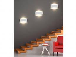 Interior view of a living area with wooden staircase, gray wall, and red armchair