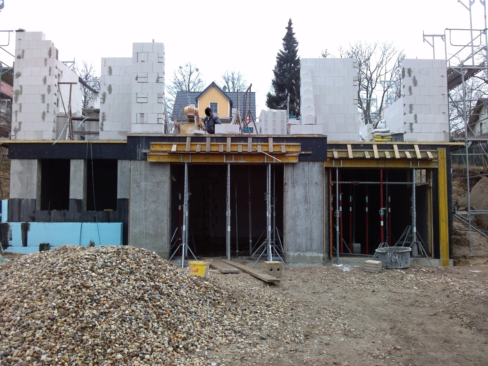 Construction site with raw foundation, white blocks, supports and scaffolding