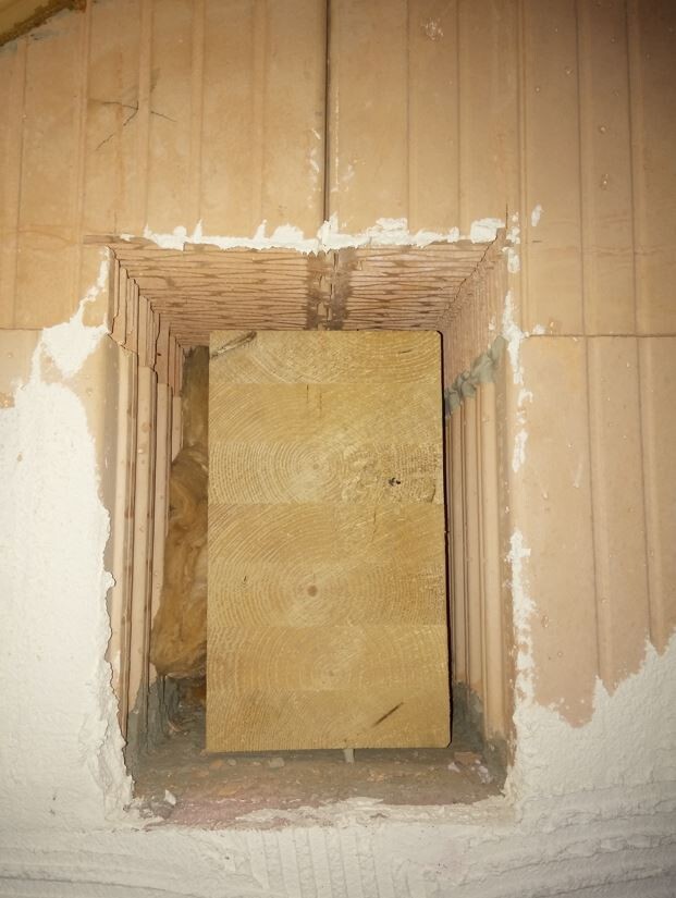 Cavity opening in masonry wall with wooden board temporary structure during shell construction
