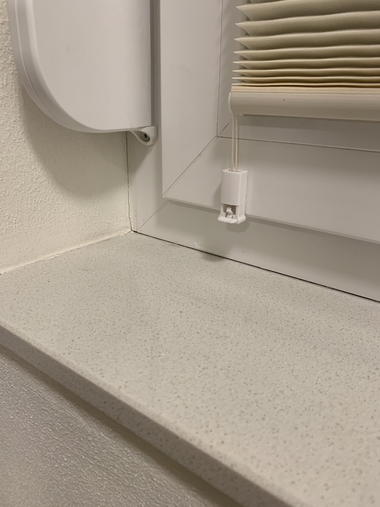 White shutter on window with window sill and pull cord