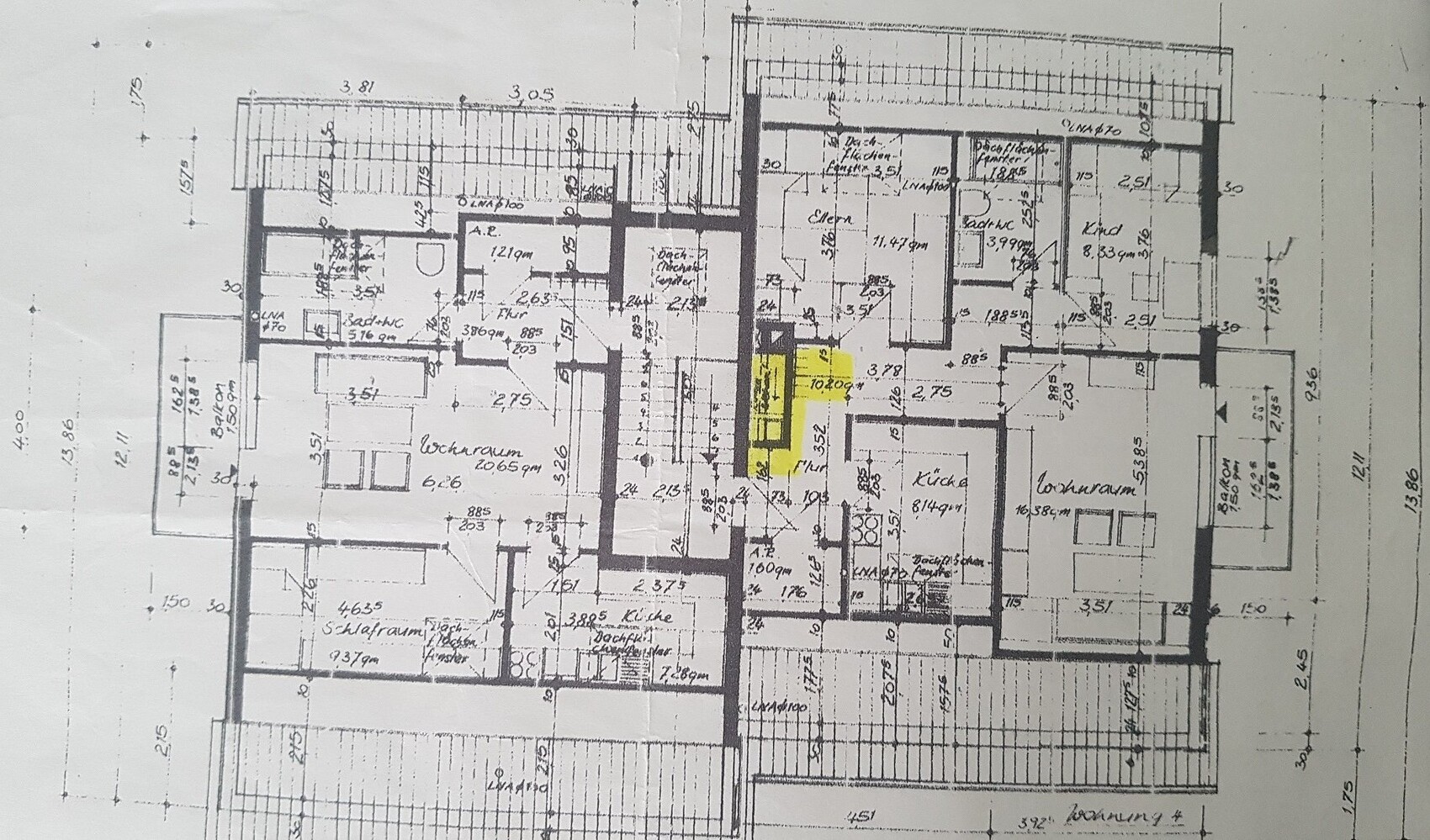 Black and white floor plan of a residential building with many rooms; yellow highlighted area in the middle.