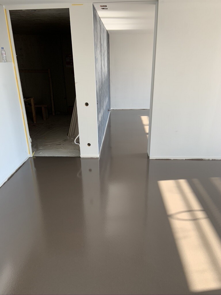 Fresh interior: hallway with glossy brown floor, open passage to a dark room on the left.