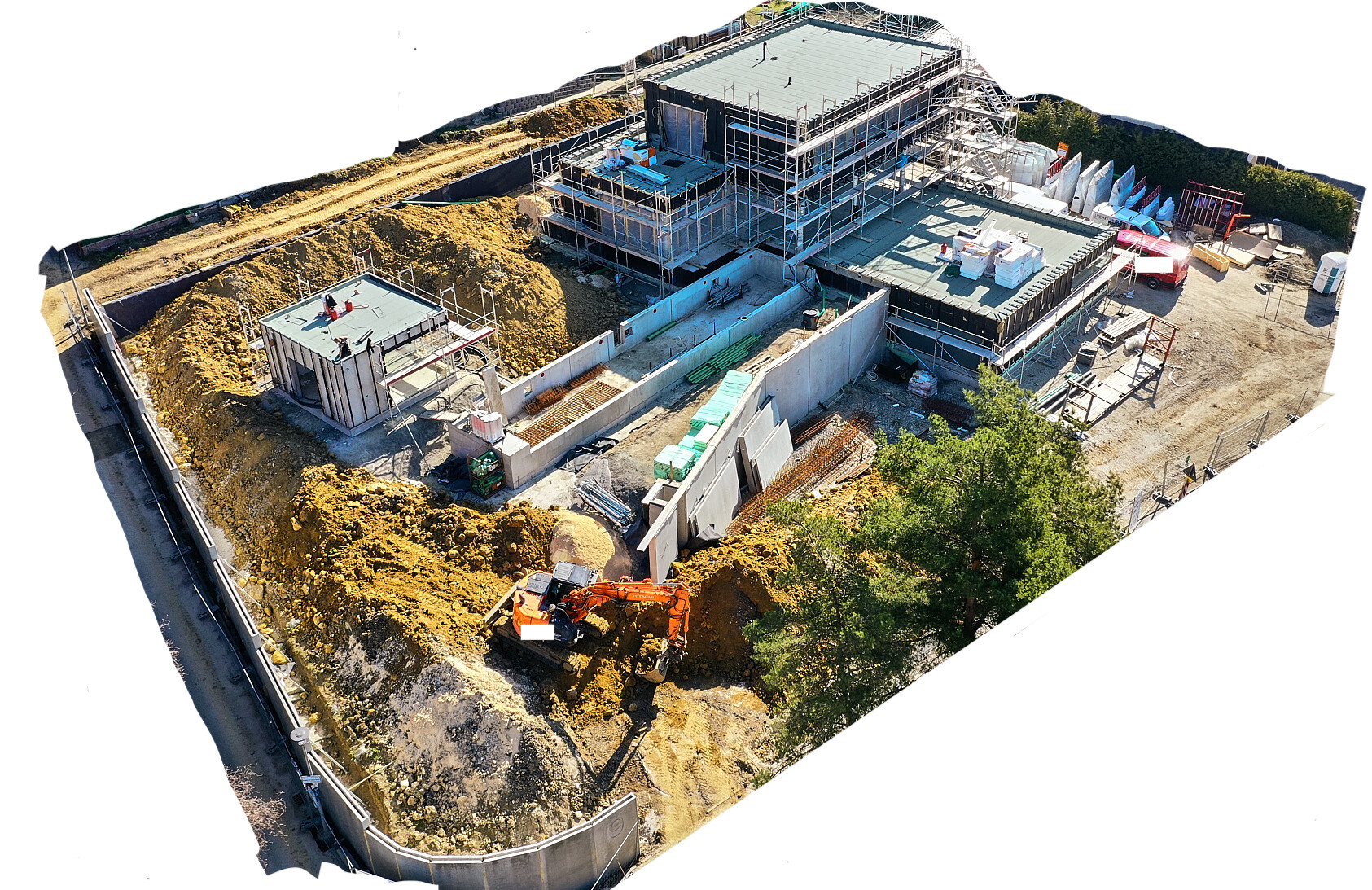 Luftbild einer Baustelle mit Gerüsten, Erdhaufen, Baggern und Baumaterial.