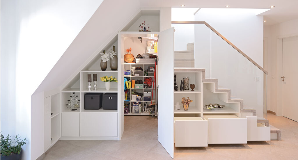 Modern, bright interior with a white staircase and open storage compartments under the stairs.
