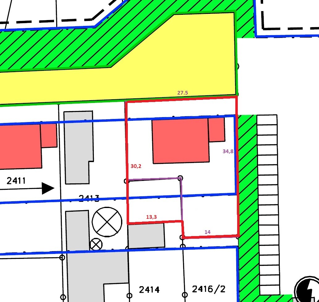 Site plan: yellow building section, green hatched zone, red property boundary, blue border lines.