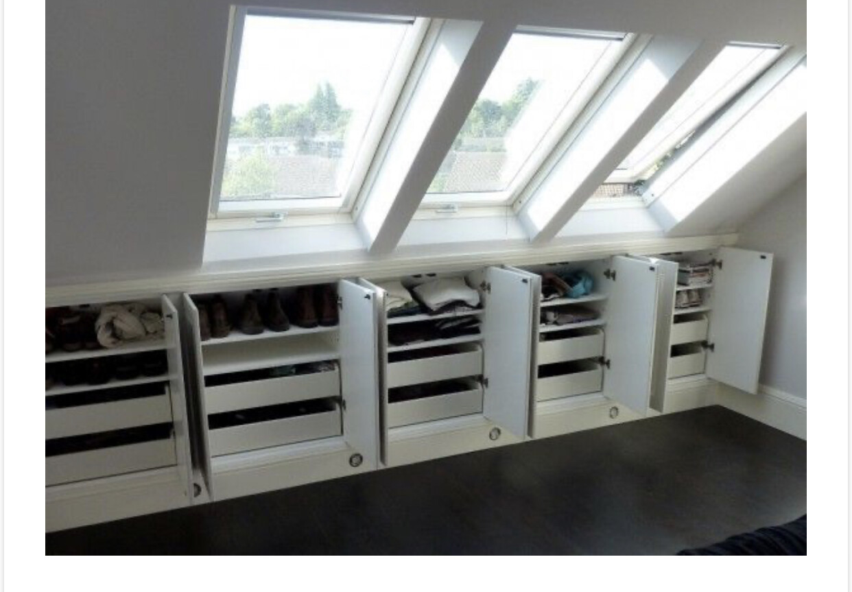 Wardrobe with open doors under skylights; clothes and shoes neatly stored.