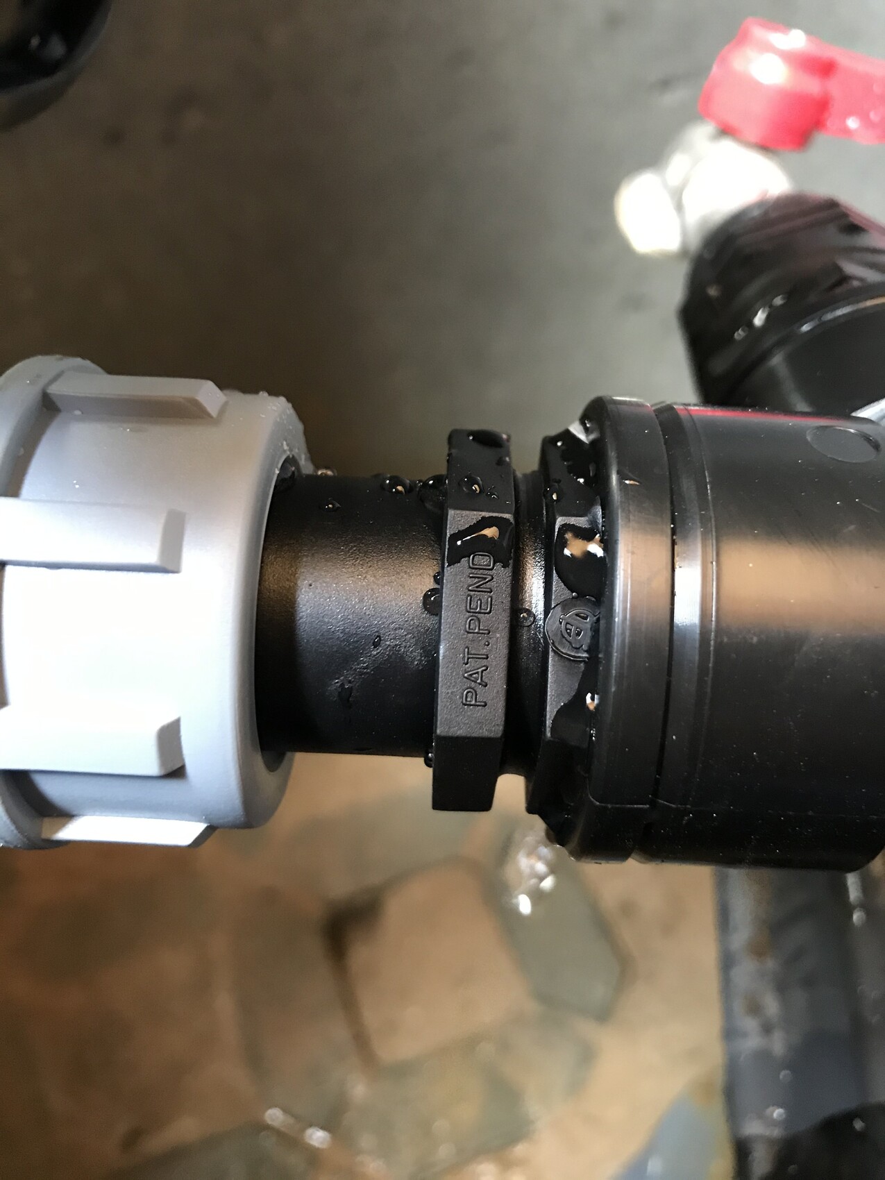 Close-up of a black connector with gray locking mechanism; PAT. PEND. visible.