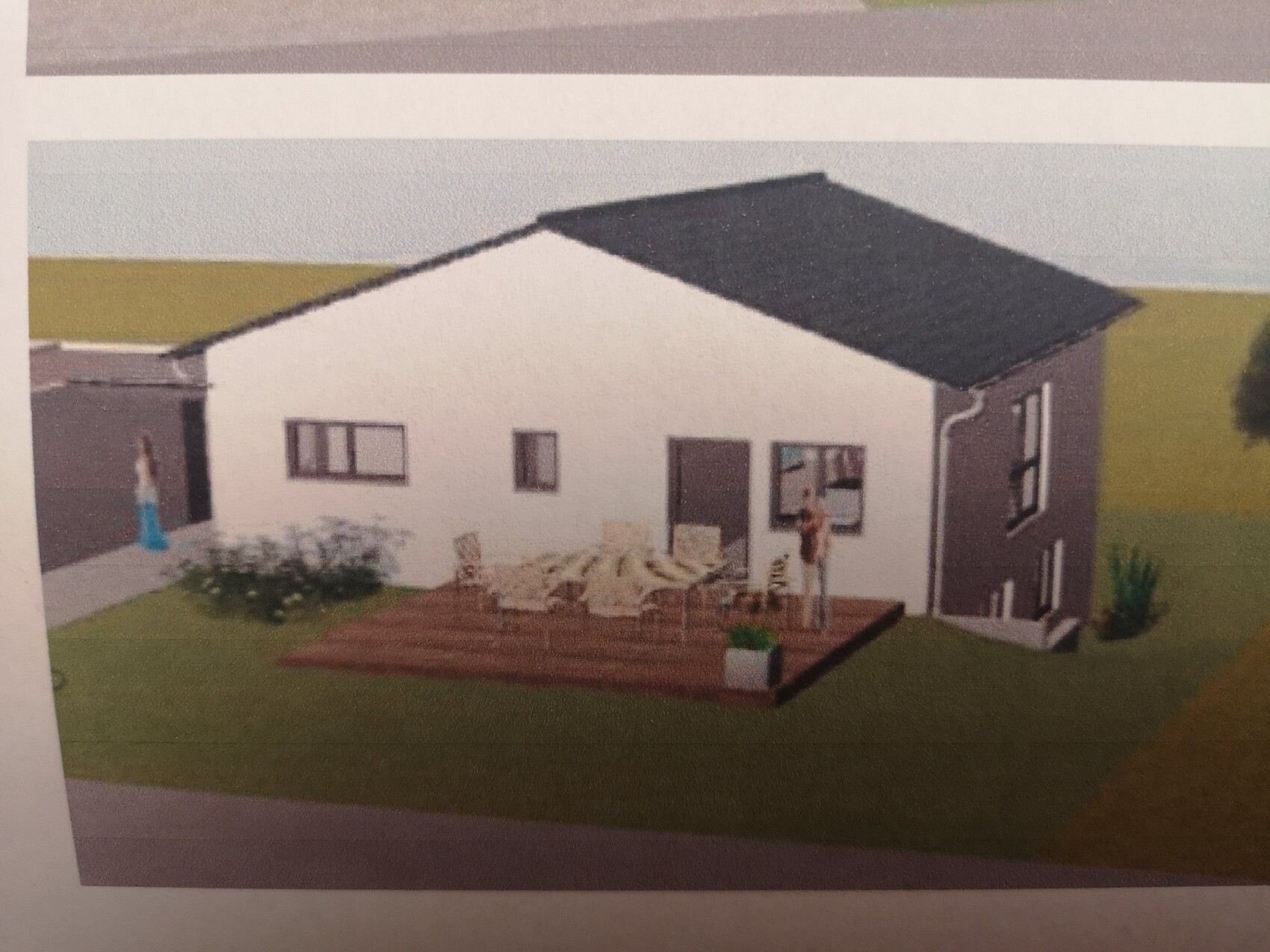 Modernes Einfamilienhaus mit dunklem Satteldach, Holzterrasse, Gartenmöbeln und einer Person am Deck.