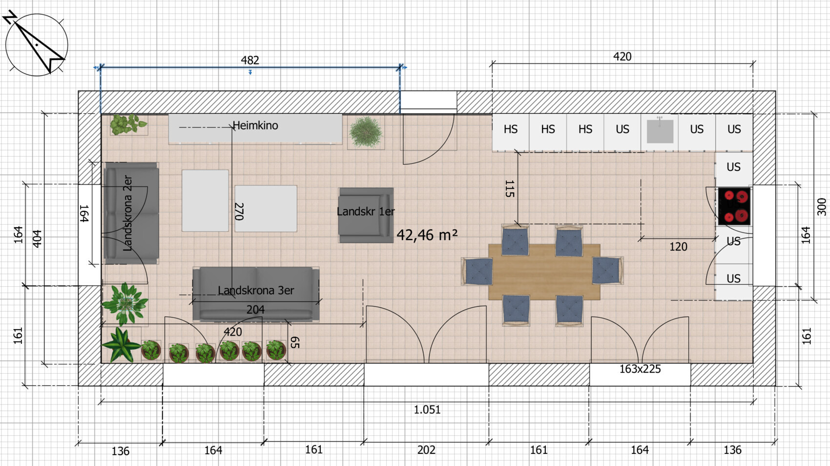 Open layout of a living and dining area with sofa, dining table, kitchenette, plants and doors.