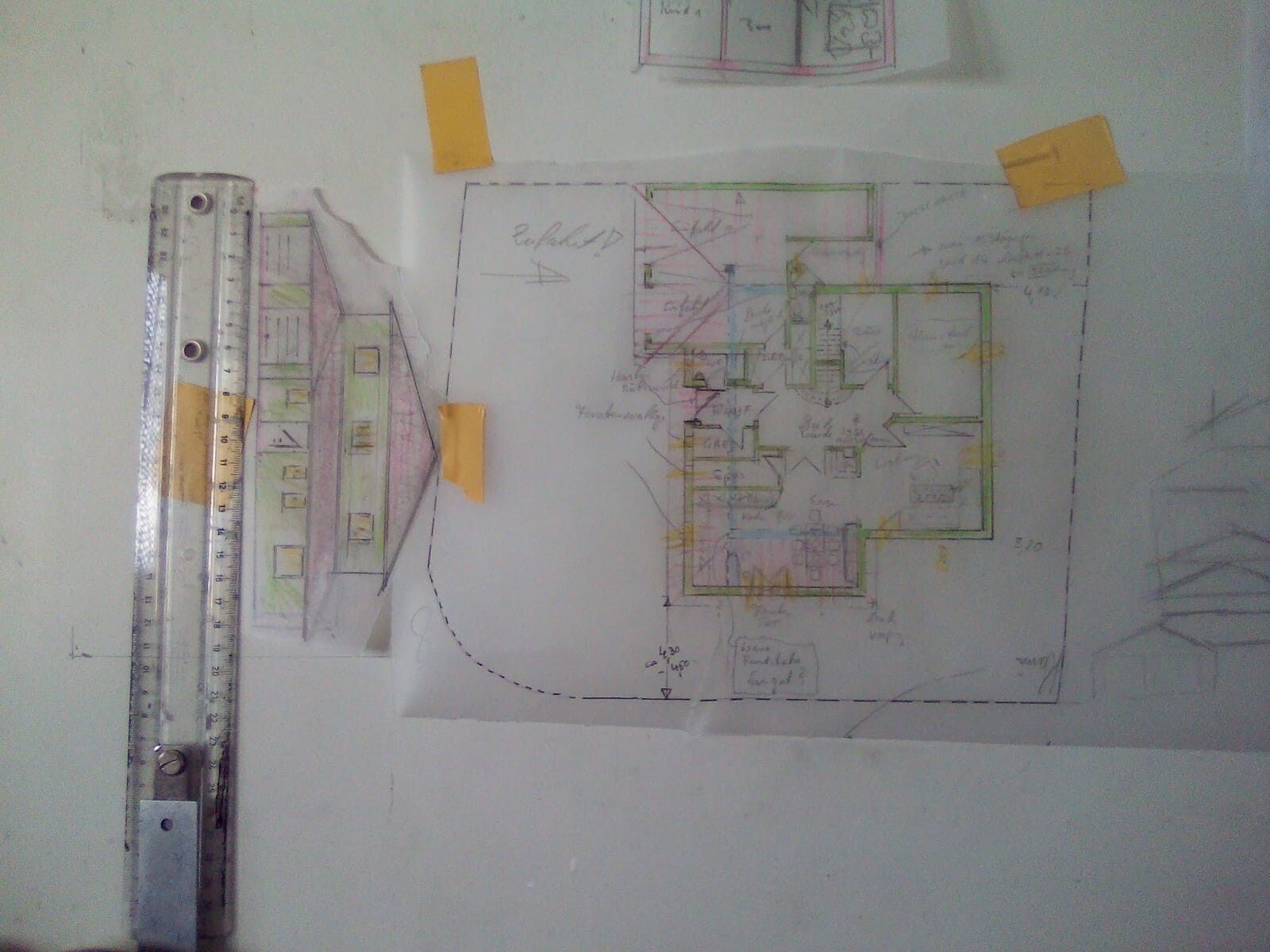 Floor plan of a building on paper with a ruler on the left and yellow sticky notes.