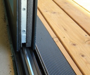 Door threshold with seal at the entrance next to wooden terrace decking