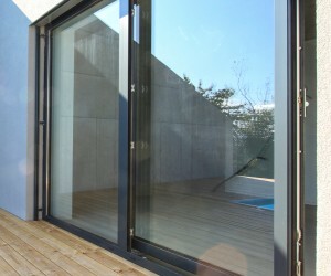 Large glass sliding door opens onto a wooden terrace with outdoor area.