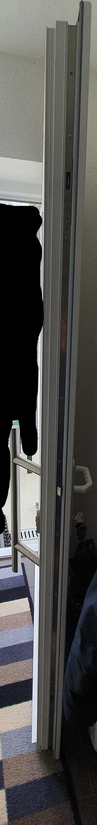 Open door; left dark silhouette of a person in the hallway next to the door frame.