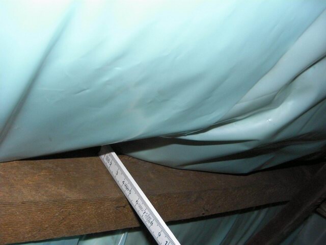 Construction site scene with blue covering material, timber beams and measuring tape